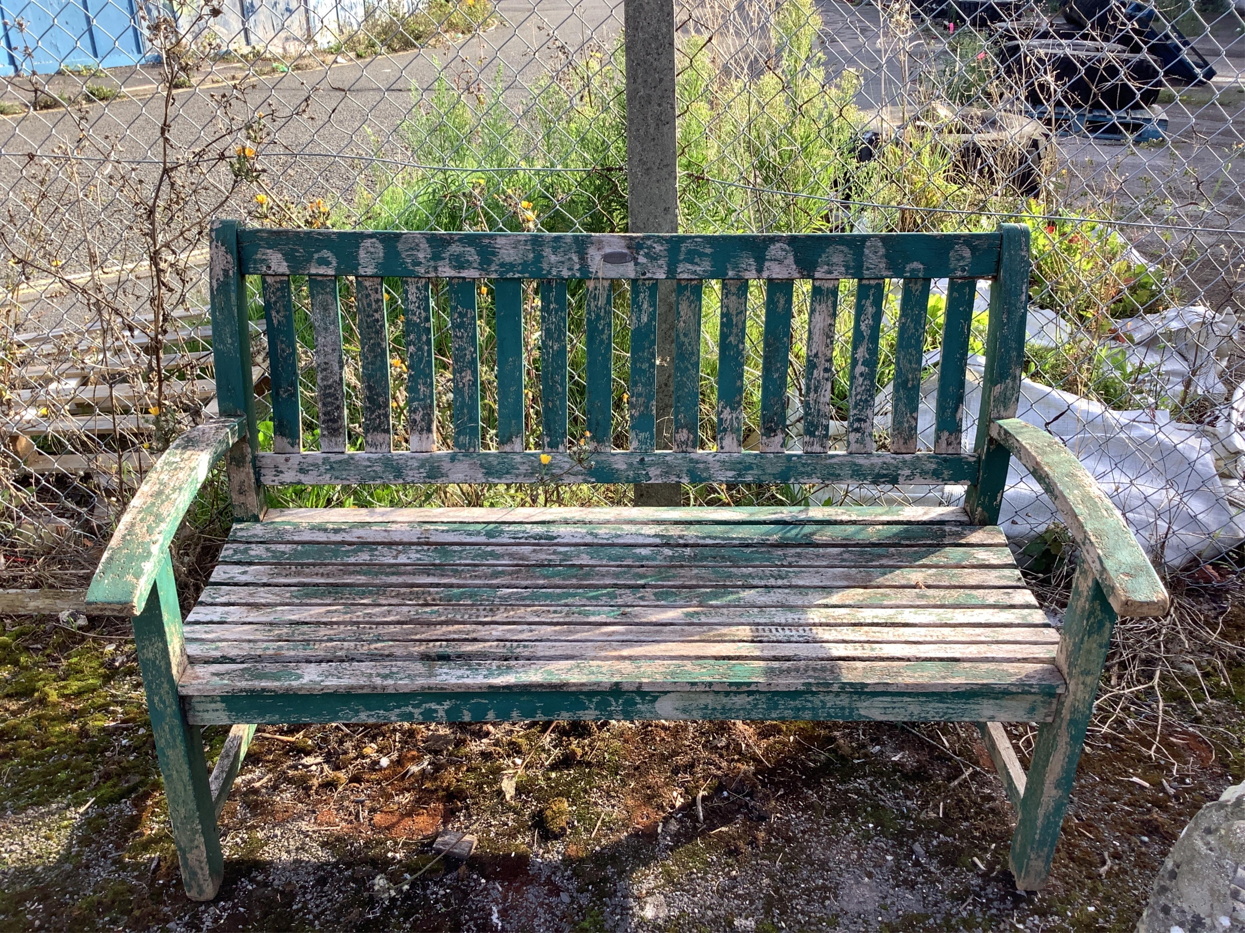 A green painted teak garden bench, width 138cm. Condition - weathered, otherwise fair